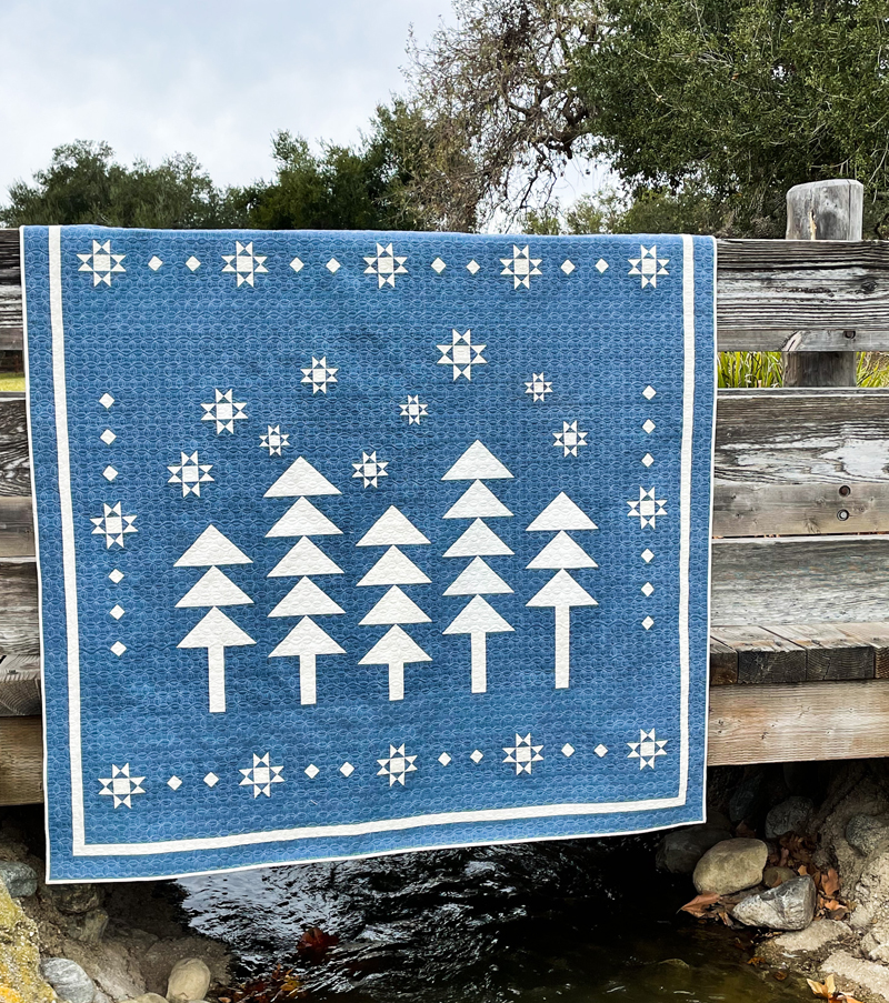 winter walk in the woods quilt on a wooden fence